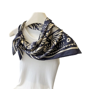 Eleganter dunkelblauer Seidenschal mit Blumenmuster und geometrischen Motiven auf Puppe