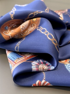 Detail eines Seidentuchs in Marineblau mit goldenen Kettenmustern und Blumenprint