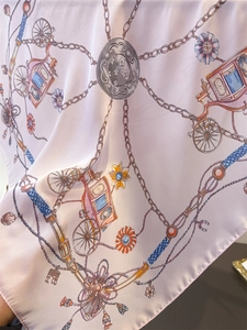Nahaufnahme eines Seiden-Quadrat-Schals mit Kutschenmuster und glatter Satin-Textur