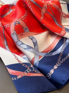 Close-up of luxury silk scarf with equestrian chain print and satin texture finish
