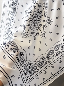 Macro shot of paisley pattern silk scarf with smooth texture and fine edge stitching