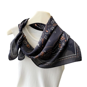 Navy blue paisley silk scarf styled on a white top for a modern bohemian look