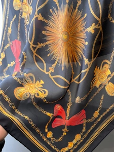 Detail of silk scarf showing vintage gold chain patterns and red ribbon accents