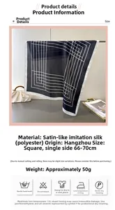 Detail view of a black satin silk square scarf with white geometric line patterns