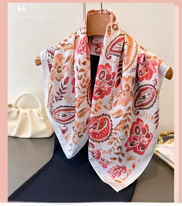 Close-up of elegant paisley and floral print silk scarf displayed on a wooden hanger