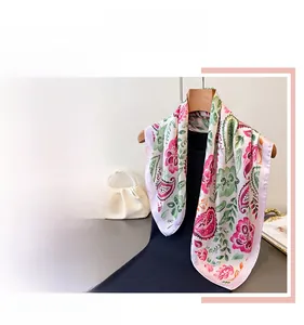 Detail of pink and green floral paisley pattern silk scarf with elegant drape and shine