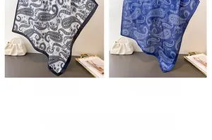 Detail view of navy blue and black paisley print silk scarves with a glossy satin finish