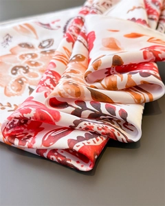 Detailed view of paisley floral print silk scarf with smooth glossy texture and vibrant colors