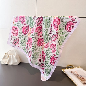 Detail of paisley and floral silk scarf showing vibrant patterns and smooth satin texture