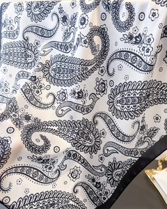 Close-up of elegant paisley silk scarf showing soft drape and luxurious satin texture