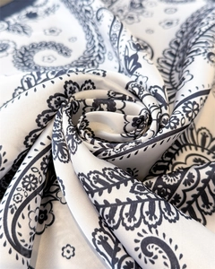 Macro detail of silk-like paisley bandana twisted into a rose shape with satin sheen