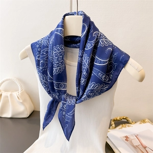 Elegant navy blue paisley silk scarf styled on a mannequin with vintage floral patterns