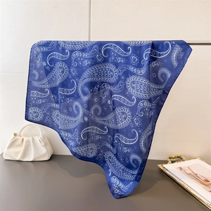 Detail of silk-like square scarf with paisley print and elegant satin finish sheen