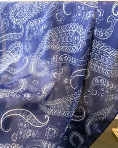 Close-up of navy blue paisley silk scarf showing soft drape and delicate texture