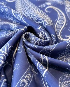 Close-up of navy blue paisley silk scarf with white floral patterns and smooth texture