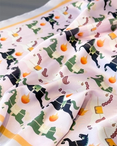Détail d'un foulard en satin lavande avec imprimés chevaux et flammes et bords jaunes