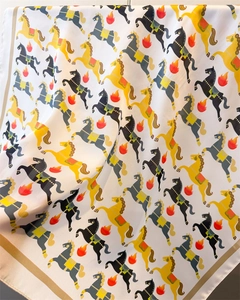 Détail d'un foulard en soie avec imprimés chevaux et flammes et bordure en satin doré