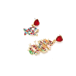 Dettaglio orecchini a pesce asimmetrici in oro con cuori rossi e strass multicolori