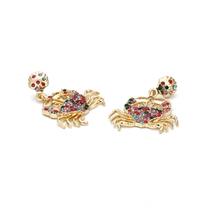 Boucles d'oreilles crabe dorées avec strass colorés sur un fond blanc épuré