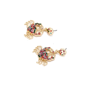 Boucles d'oreilles crabe exagérées avec strass colorés sur une monture dorée
