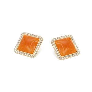 Detailed view of square orange resin earrings with gold-tone base and sparkling zircon frame