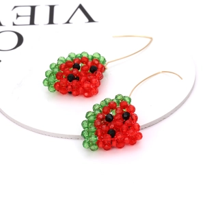 Macro detail of handmade beaded watermelon earrings with vibrant red and green beads