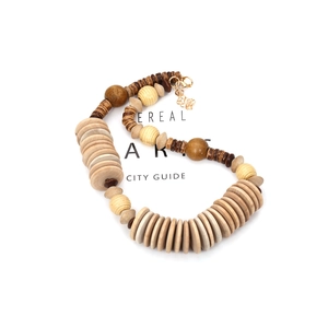 Detail of bohemian wooden beaded necklace with geometric charms and gold lobster clasp