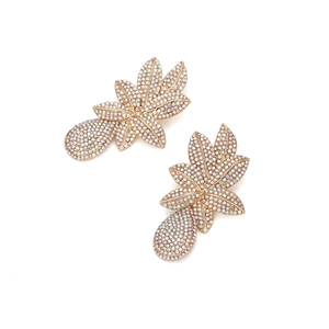 Détail macro de boucles d'oreilles en feuilles avec strass AB et finition dorée