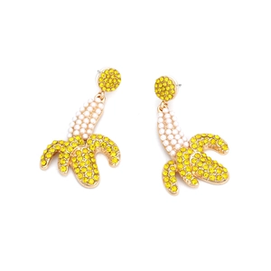 Sparkly banana drop earrings with yellow rhinestones and pearls on a white background