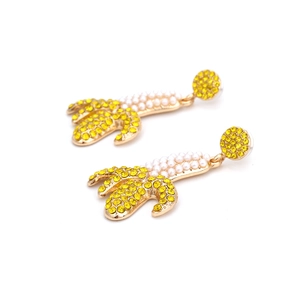 Exaggerated rhinestone banana earrings with pearls and gold accents in a retro style