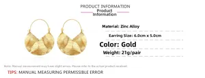 Detailed view of large gold fan-shaped creased hoop earrings with brushed texture