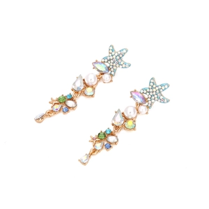 Detail of starfish drop earrings with teal crystals and pearls on gold-tone alloy