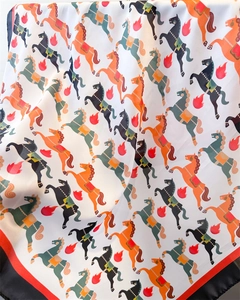 Détail du foulard en soie montrant des imprimés chevaux colorés et des bords contrastés