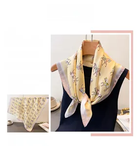 Detailed close-up of light yellow silk scarf featuring colorful pony prints and textures