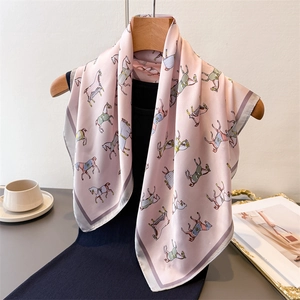 Pink faux silk square scarf with horse print on a black garment with an elegant hanger