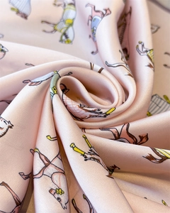 Detail of pink silk scarf showing horse print texture and soft folding fabric