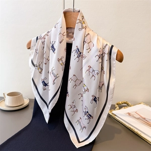 Elegant cream silk scarf with horse print on hanger with black dress and afternoon tea