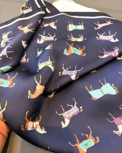 Close-up of dark blue silk scarf featuring classical equestrian horse print and satin texture