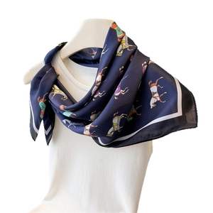 Elegant navy blue silk scarf with equestrian horse print tied on a white vest model