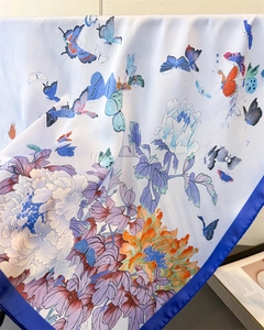 Detailed texture of silk-like scarf with butterfly and peony prints and blue borders