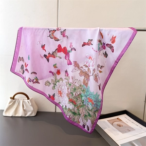 Detail of silk square scarf showing butterfly and peony print with premium hand-rolled edges