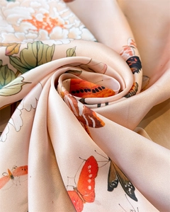 Close-up of butterfly and peony floral print on silk satin scarf with elegant folds