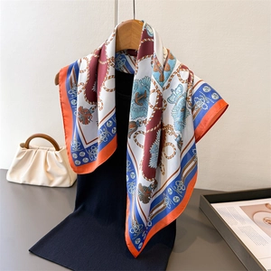 Navy style silk scarf with crown and anchor prints draped over a black knit top