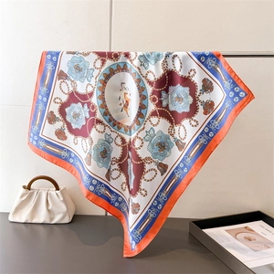 Detail of equestrian silk-like scarf with royal horse print and orange rolled edge