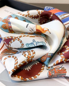 Close-up of silk square scarf featuring detailed equestrian prints and horse motifs