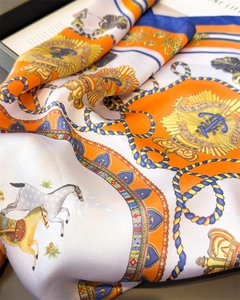 Detail of equestrian print silk scarf showing glossy texture with horse and rope patterns