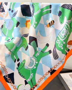 Detail of silk-like scarf featuring green pony prints and fine orange hemmed edges