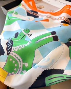 Detail of silk scarf with cartoon horse prints and colorful checkered border pattern