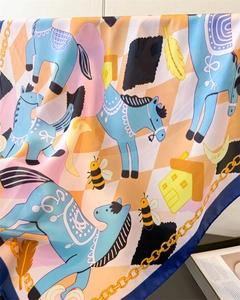 Macro detail of silk-feel scarf with chain and pony print on pastel checkered base