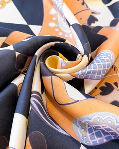 Detail of satin silk scarf featuring orange equestrian horse prints and checkered pattern